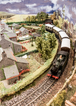 Model Train & Railway Carriages Passing Through The Countryside