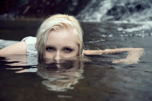 Young woman half submerged in the water