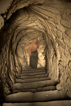 Covered Woman Descending Ancient Stairs