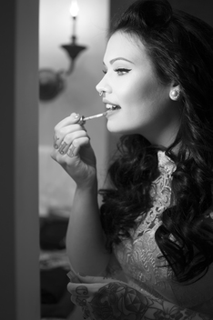 A woman applying lip gloss