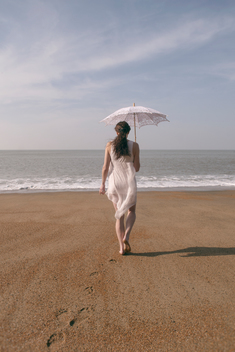 Woman on beach with vintage parasol